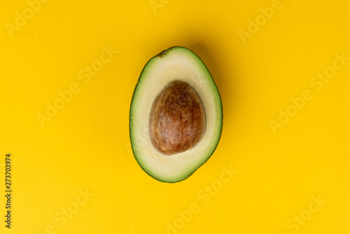 Avocado fruit on yellow background.