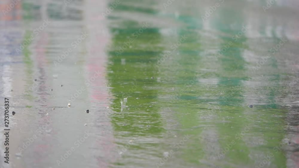 Rain dripping on asphalt.