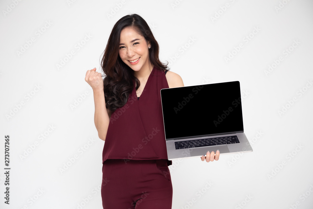Portrait of an excited Asian woman holding laptop computer and celebrating success over white background, Raising arms with a look of happiness, Female model Portrait of an excited Asian woman holding laptop computer and celebrating success over white background, Raising arms with a look of happiness, Female model