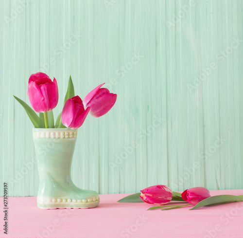 pink tulips in vase on wood...