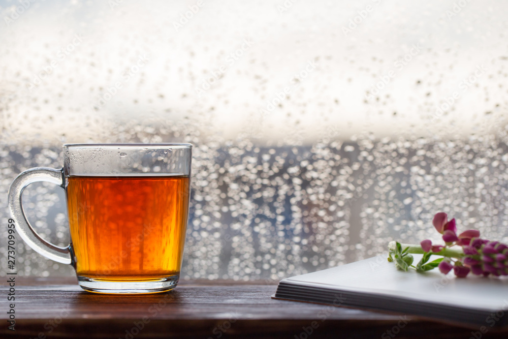 cup of tea on background of window with raindrops at sunset cup of tea on background of window with raindrops at sunset