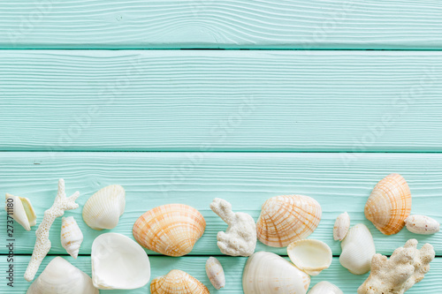Summer at the sea design for blog with shells on mint green wooden background top view copy space