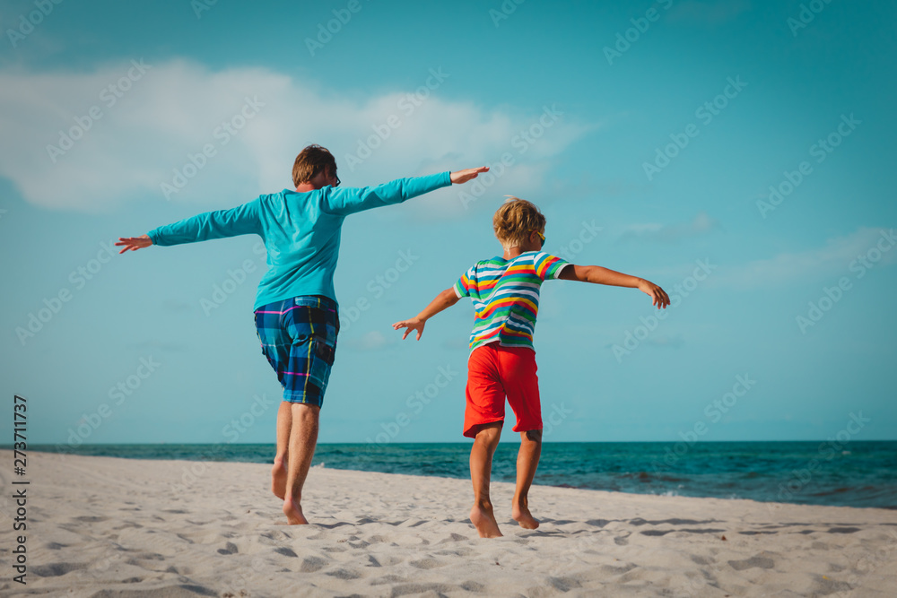 father and son play on beach, family enjoy vacation at sea father and son play on beach, family enjoy vacation at sea