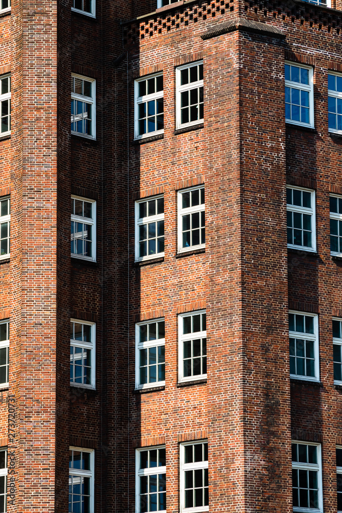Obraz premium Facade of an old house with red brickwalld and white windows in an inner city in germany in summer