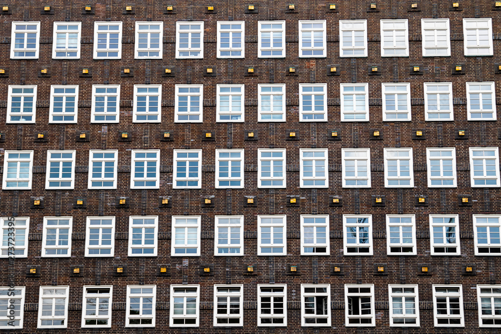 A lots of windows on the facade of a house in the inner city of hamburg in germany with brick wall A lots of windows on the facade of a house in the inner city of hamburg in germany with brick wall