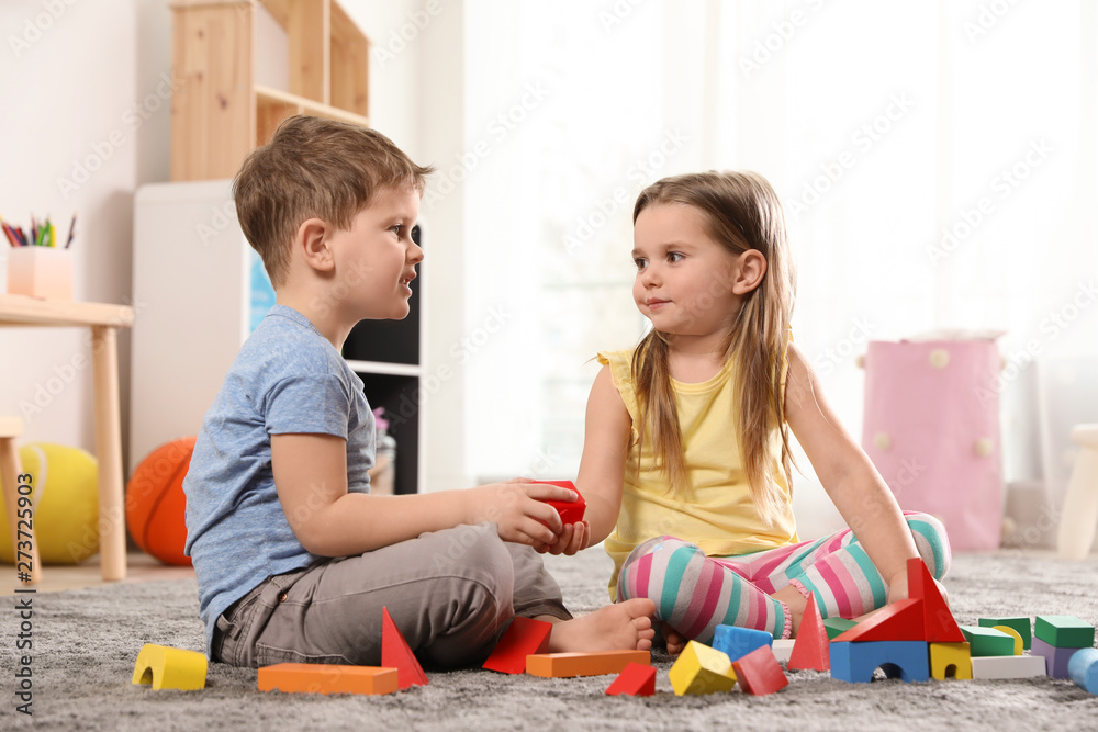 Obraz premium Little children playing with colorful blocks indoors