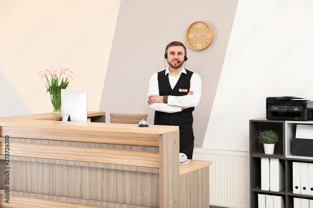 Portrait of receptionist working at desk in modern hotel Portrait of receptionist working at desk in modern hotel