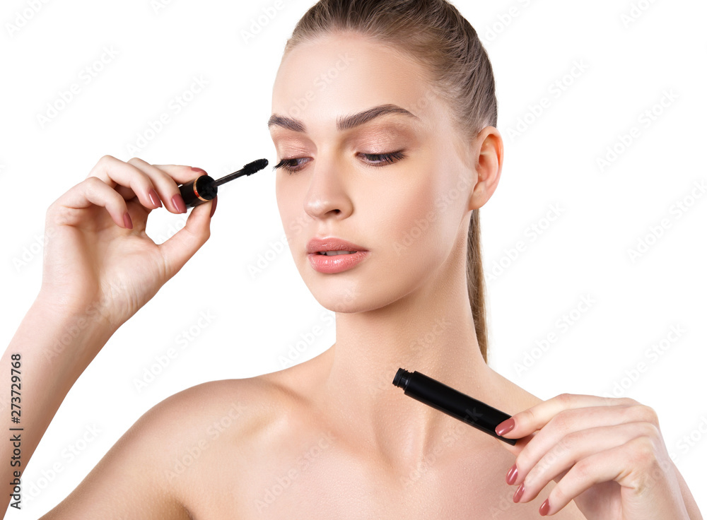 Beautiful woman applying mascara on her eyelashes