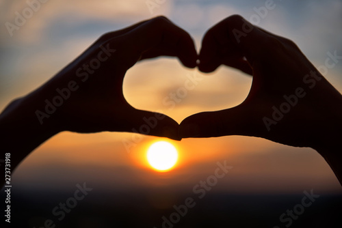 Concept or conceptual woman hands in love  symbol of heart over Montreal background. Heart shape making of hands against bright sunset and sunny golden