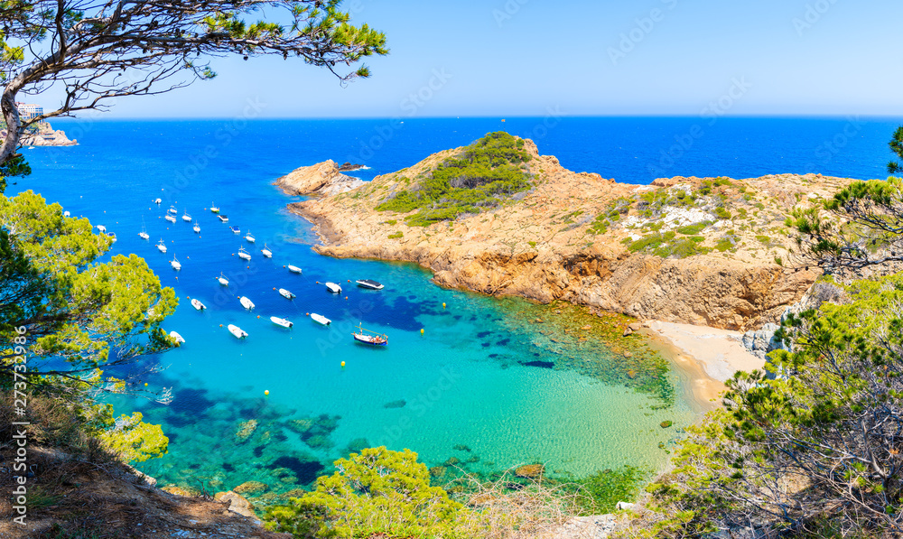 Panoramic view of boats in beautiful sea bay with beach near Sa Tuna village, Costa Brava, Spain