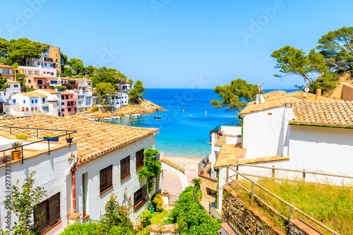 White houses with orange tile roofs and steps to beach in Sa Tuna coastal fishing village, Costa Brava, Spain