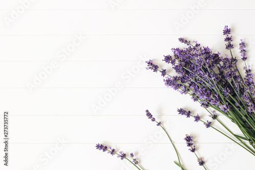 Bouquet of lavender flowers on white wooden table background. Decorative floral frame  web banner with Lavandula officinalis. French summer design  aromatherapy concept. Healthy fragrant herbs.