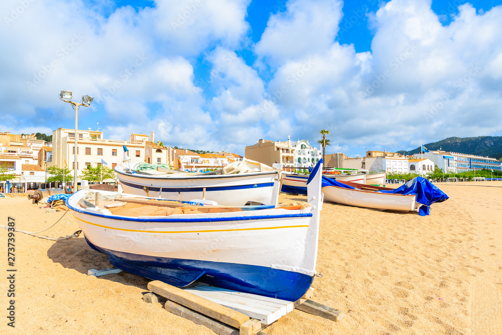 Fishing boats on golden sand beach with white houses in background, Tossa de Mar, Costa Brava, Spain Fishing boats on golden sand beach with white houses in background, Tossa de Mar, Costa Brava, Spain