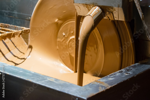 Chocolate melting machine in progress. Chocolate pouring down. Close up.