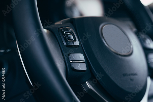 Audio control buttons on the steering wheel of a modern car