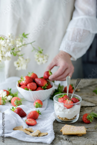 Faceless chef using fresh juicy tasty strawberries while preparing creamy sweet dessert photo