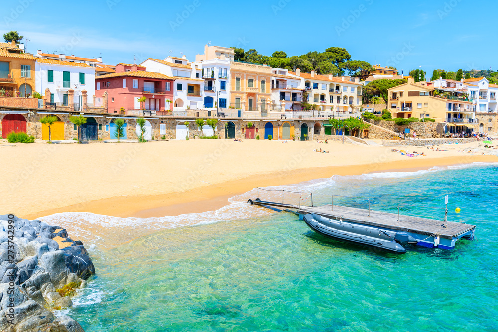 Fototapeta premium Boats on Canadell beach in Calella de Palafrugell village with colorful houses on shore, Costa Brava, Catalonia, Spain