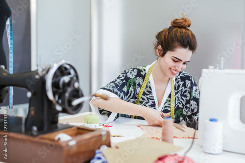 Teenage girl student practicing sewing on modern machine in cozy workshop photo