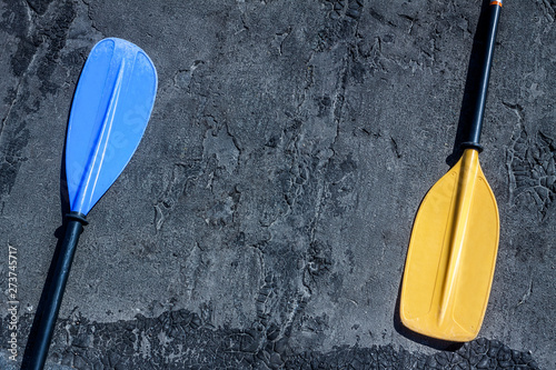 Blue and yellow paddles on the gray textured background laying on both sides photo