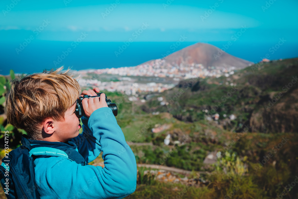 young boy looking through binocular on travel in nature young boy looking through binocular on travel in nature