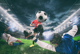 Close up of a football action scene with competing soccer players at the stadium during a night match