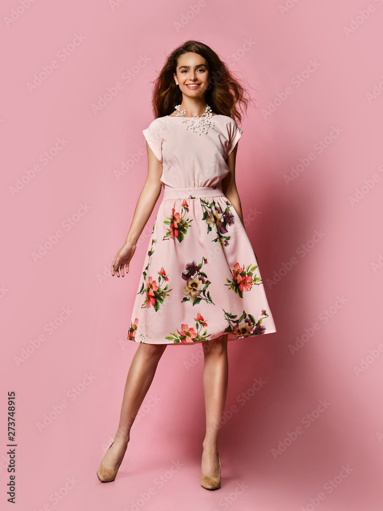 Cute slender girl in red dress for a date - a blouse and a fluffy skirt posing in the studio on a pink background. to meet spring and summer. Wardrobe update Cute slender girl in red dress for a date - a blouse and a fluffy skirt posing in the studio on a pink background. to meet spring and summer. Wardrobe update