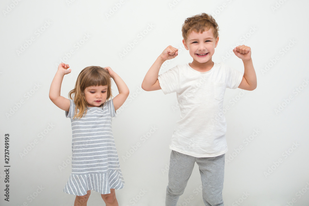 Cute smiling sport two kids showing biceps on a white background Cute smiling sport two kids showing biceps on a white background