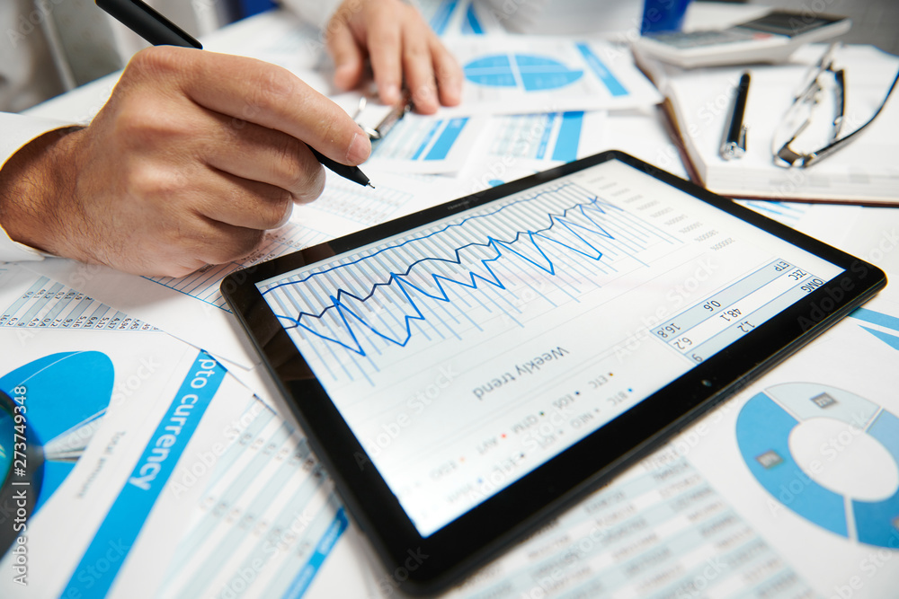 Businessman working and calculating, reads and writes reports. Using tablet pc. Office employee, table closeup. Business financial accounting concept. Businessman working and calculating, reads and writes reports. Using tablet pc. Office employee, table closeup. Business financial accounting concept.