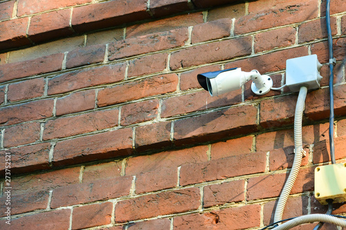 Security camera mounted on a brick wall.