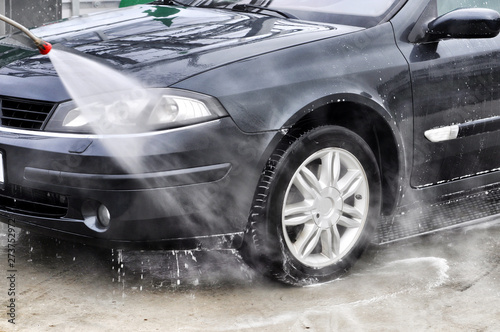 Cleaning Car Using High Pressure Water. Man washing his car under high pressure water in service