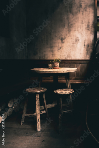 Dramatic photo a woodent table and chairs in a corner of a English Pub