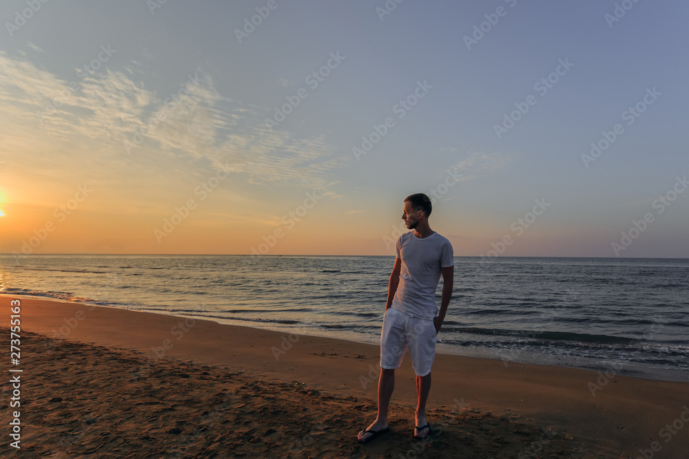 a guy in a white T-shirt and shorts holds his hands a guy in a white T-shirt and shorts holds his hands