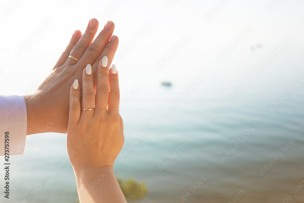 Wedding couple holding hands on sea sunset background Wedding couple holding hands on sea sunset background