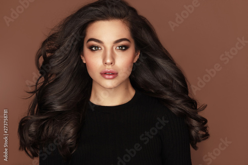 Fototapeta Brunette haired Woman Portrait with blue eyes and Healthy Long Shiny Wavy hairstyle