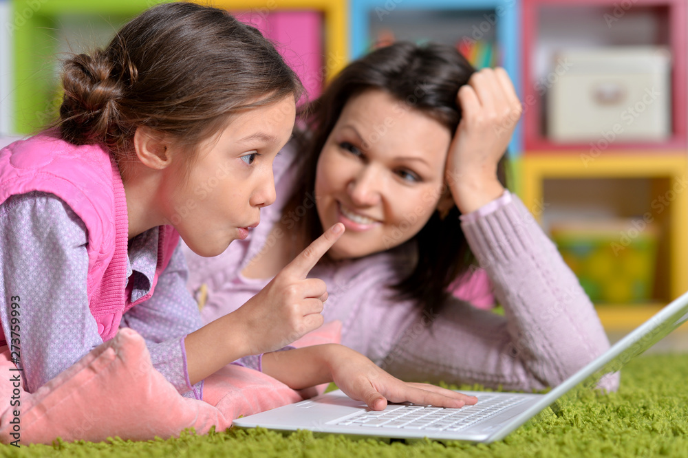 Mother with her little daughter using laptop Mother with her little daughter using laptop