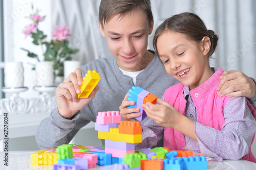 Brother and sister playing with colorful plastic blocks