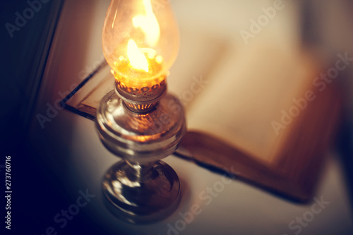 Valokuva Vintage kerosene lamp and old open book