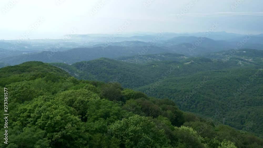 View of the mountain range covered with forest with blue sky and haze over the mountains View of the mountain range covered with forest with blue sky and haze over the mountains