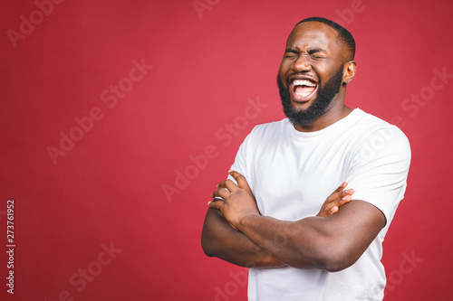 Portrait of African American man laughing isilated over red.