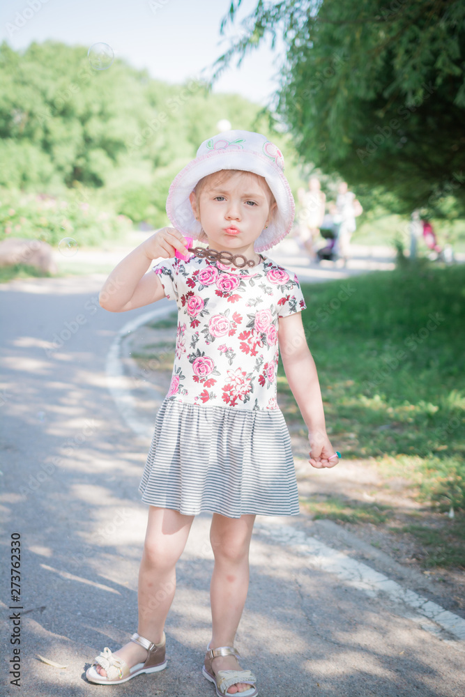 little girl blowing soap bubbles in summer park little girl blowing soap bubbles in summer park