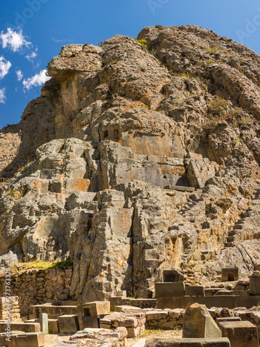 View of the Inka Misana, an aqueduct carved in the mountain rock face and a liturgical fountain, small stairways, niches or false openings sculpted in the mountain surface. In Sacred Valley, Peru