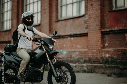 man enduro motorcycle driver in the city. biker in a helmet.