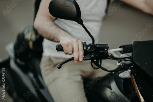 hand of the biker presses the brake on the handle.