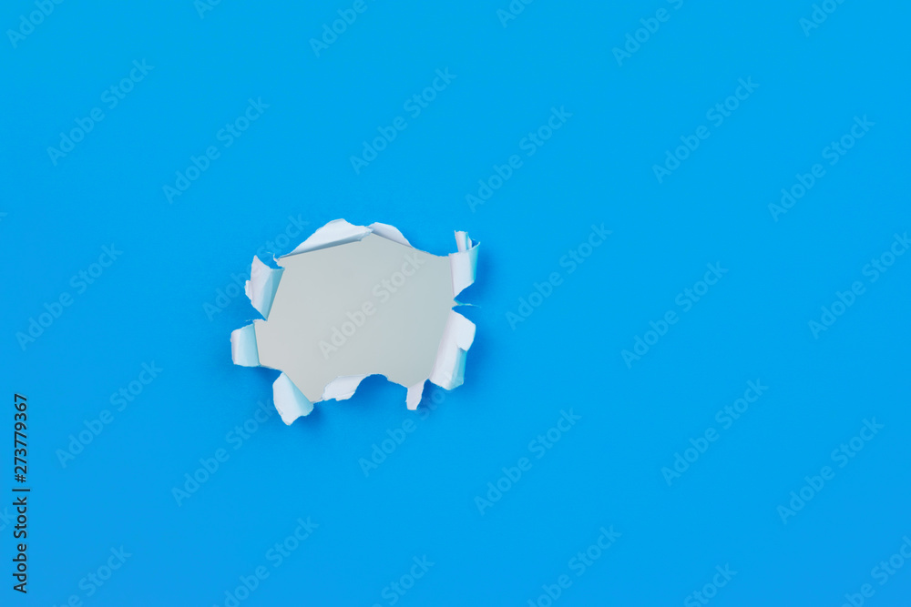 Vivid blue paper with ripped torn hole and copy space for text. Texture / design element image. Vivid blue paper with ripped torn hole and copy space for text. Texture / design element image.