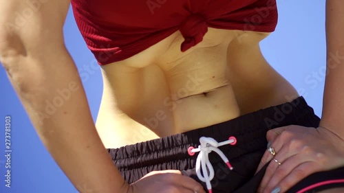Close-up shot of a woman doing belly dancing outside.