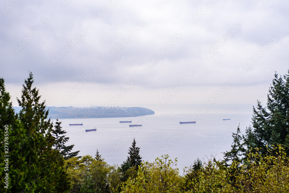 Large cargo ships anchored in bay near Vancouver, BC, Canada.