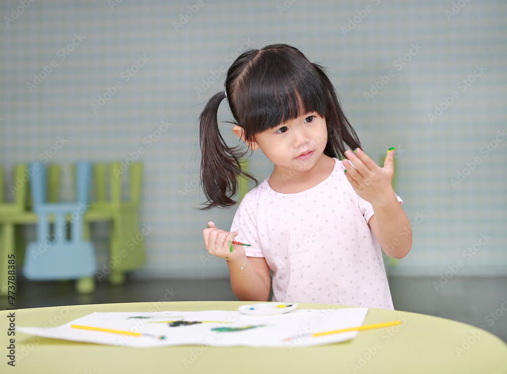 Child girl painting with paintbrush and water colors. Kid activities concept. Child girl painting with paintbrush and water colors. Kid activities concept.