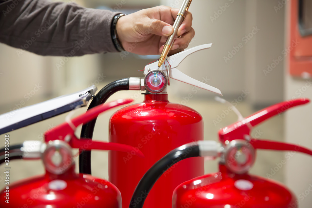 Red Fire extinguishers in the building,Engineers are checking fire extinguishers.