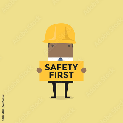 African businessman holding safety first sign.