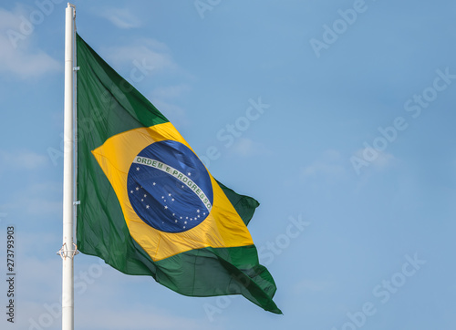 Brazil flag waving at the wind against blue sky